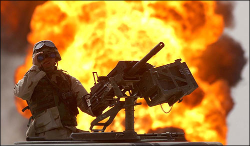 2003년 이라크군이 퇴각하면서 불을 지른 이라크 남부 루메일라 유전에서 미군병사가 쌍안경으로 주변을 살피고 있다.